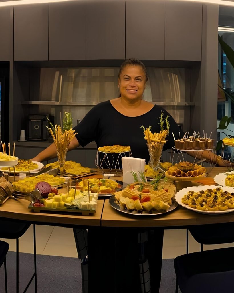 Viviane Costa, fundadora da Aipim na Manteiga, diante de uma mesa de buffet